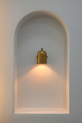 Cylindrical hallway wall light producing a soft downward pool of warm light for corridors and entryways
