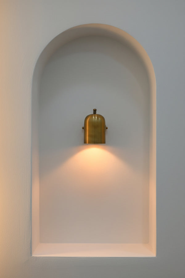 Cylindrical hallway wall light producing a soft downward pool of warm light for corridors and entryways