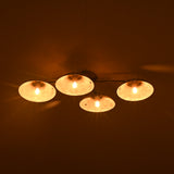 Nighttime view of 4-light brass flush mount light glowing warmly against a dark ceiling.