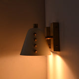 Wall sconce pair showing decorative side ball details, white tapered shades, and warm ambient light effect