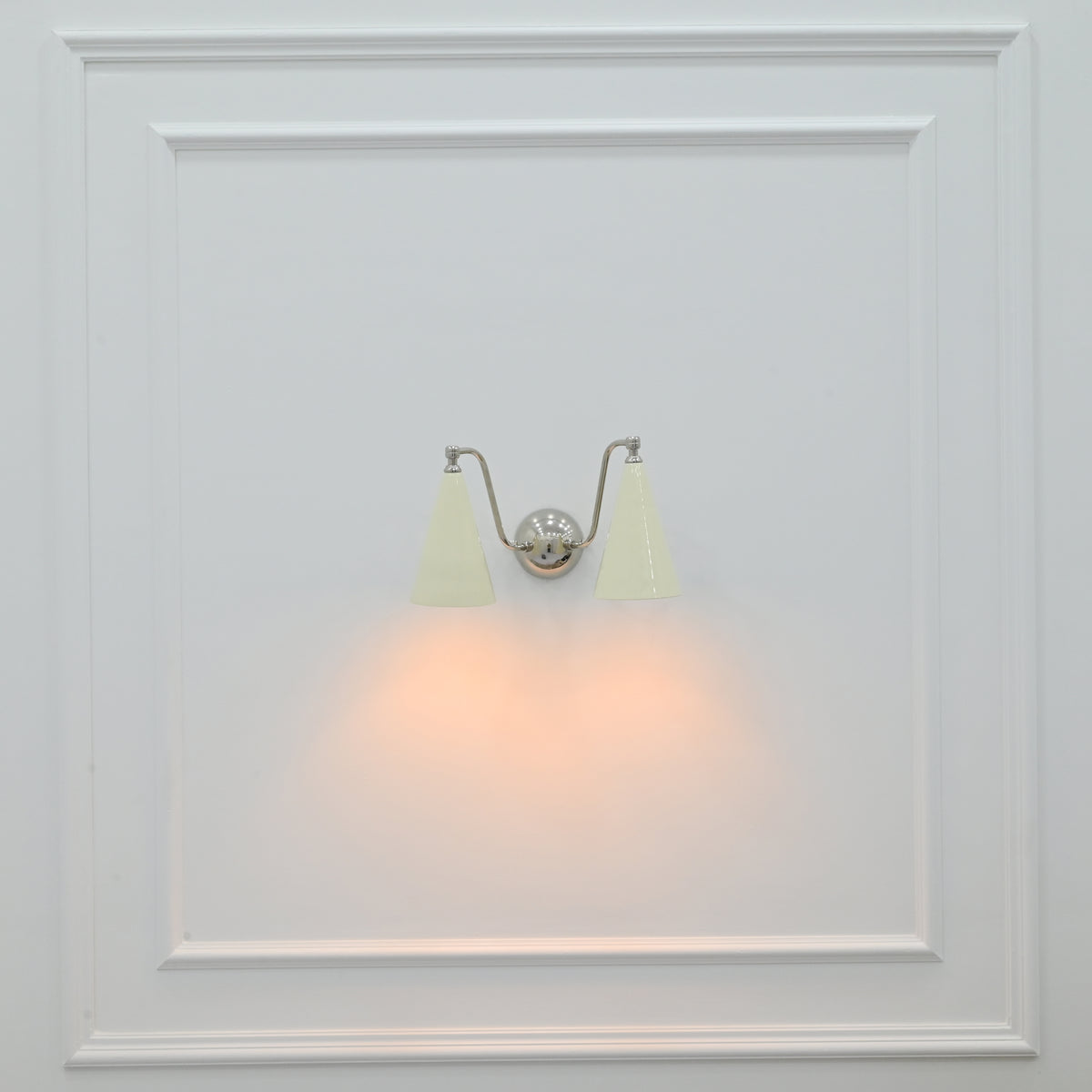Delphi 2 light wall sconce installed beside a bed with ivory cone shades and warm downward glow
