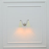 Delphi 2 light wall sconce installed beside a bed with ivory cone shades and warm downward glow