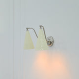 Ivory enamel wall sconce with two tapered shades and polished chrome mounting details