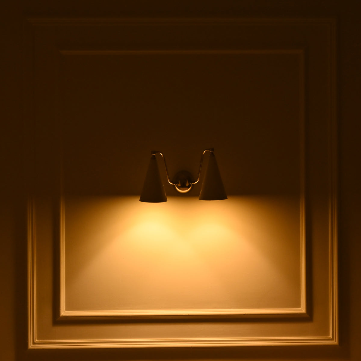 Modern two light cone wall sconce with sculptural ivory shades and reflective chrome brass arms