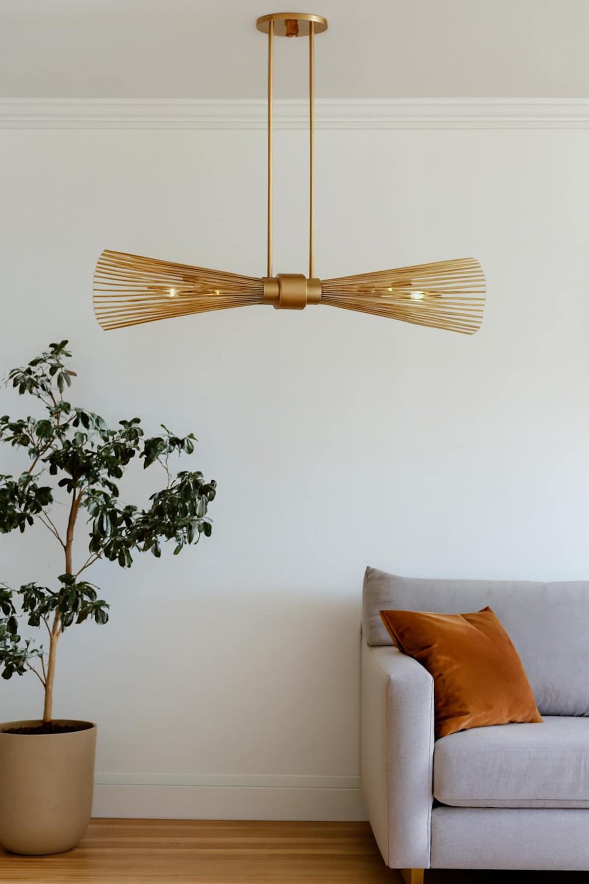 Designer linear brass chandelier hanging over modern interior, handcrafted industrial brass ceiling light
