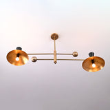 Top view of Diabolo 4-light brass chandelier featuring wide spun-brass bowl shades and black cone accents in a mid-century modern design.