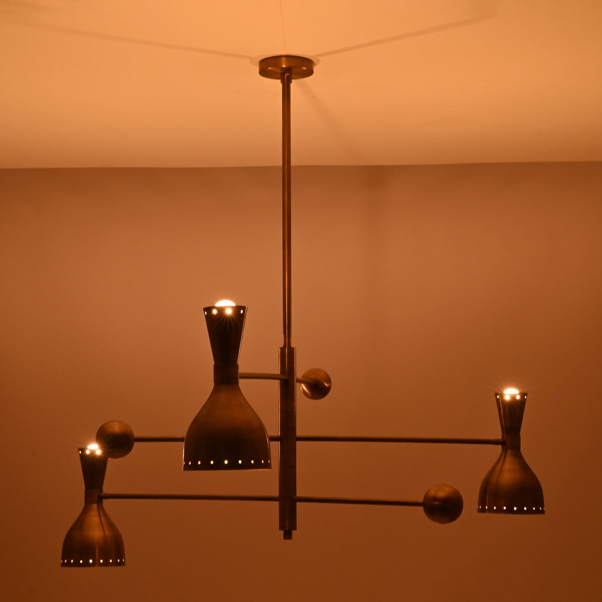 Artistic angle of Diabolo designer brass chandelier highlighting geometric balance, premium craftsmanship, and atmospheric lighting.