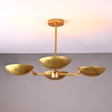 Brass chandelier with 4 upward bowls above dining table, creating a warm, elegant dining mood