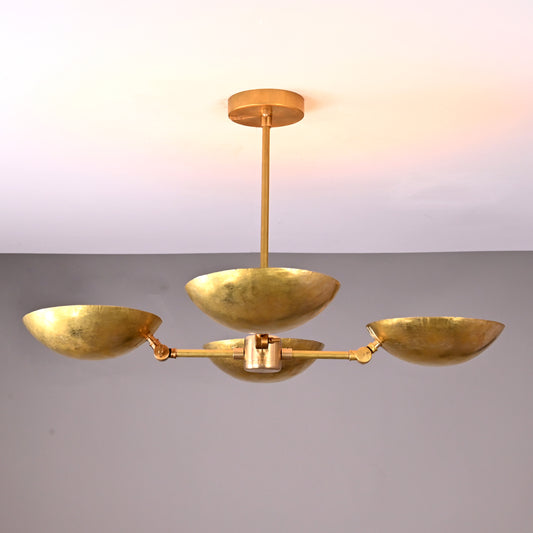 Brass chandelier with 4 upward bowls above dining table, creating a warm, elegant dining mood