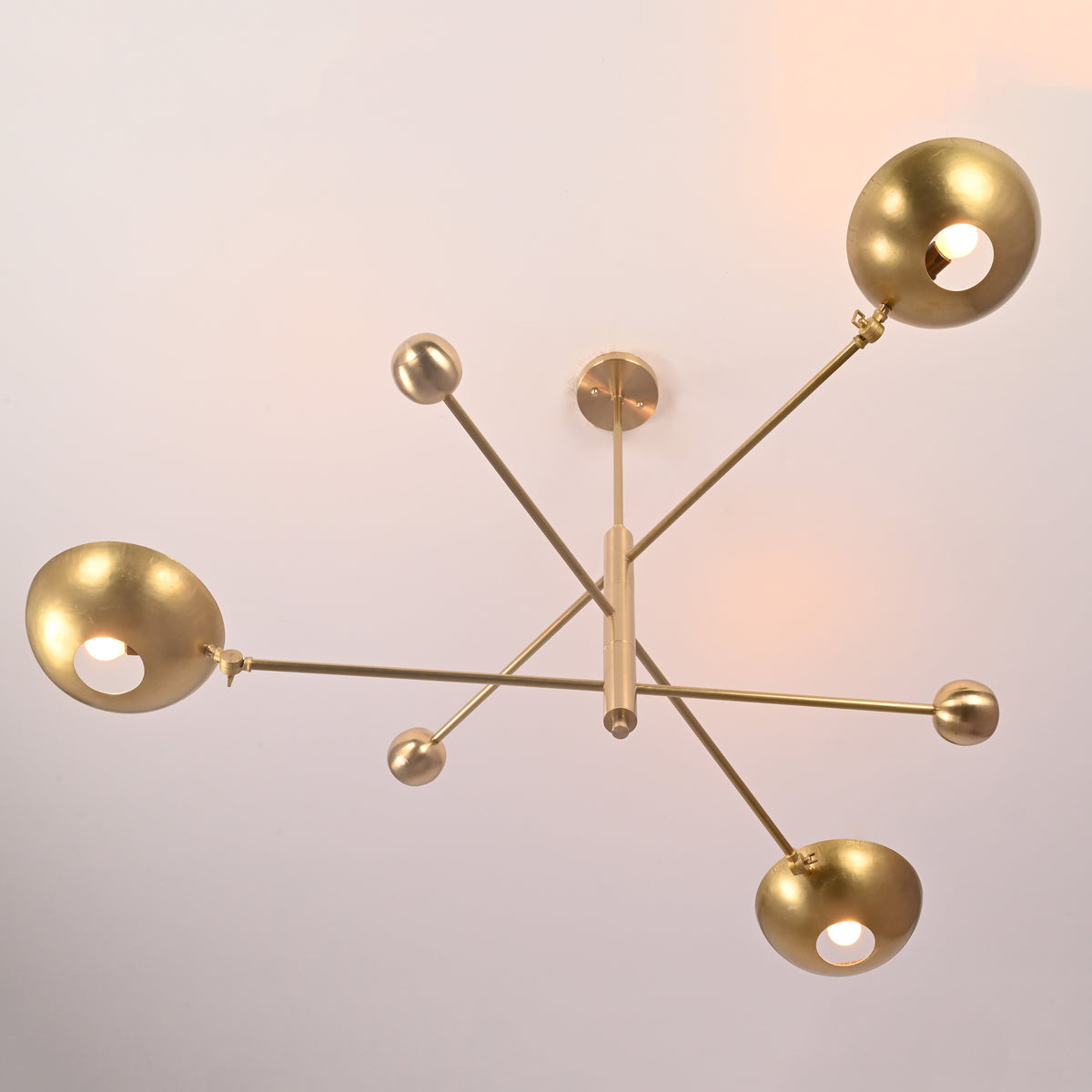 Bottom view of disc style brass chandelier highlighting balanced geometry and bowl shades