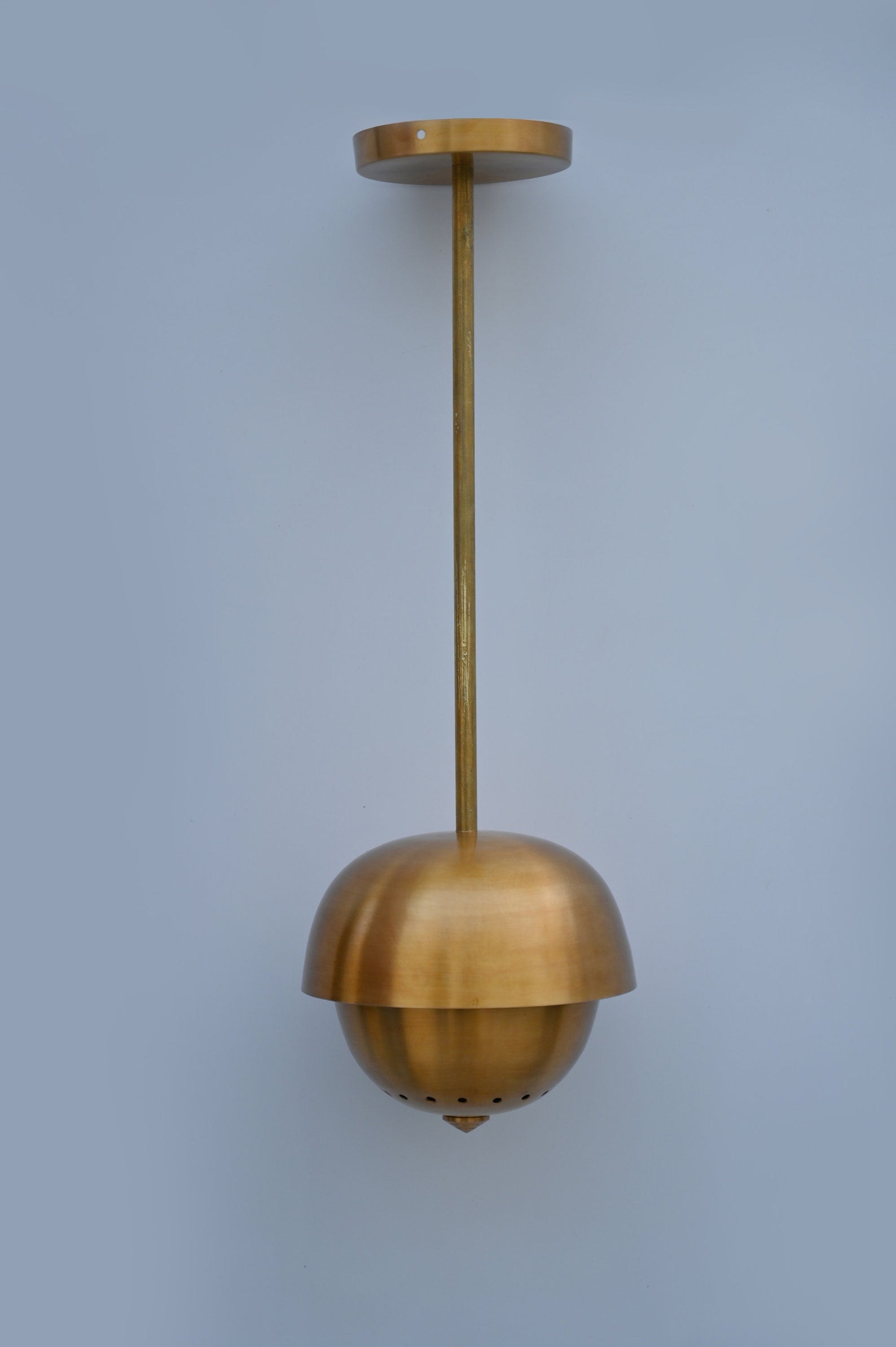 Full-length view of handmade dome brass pendant with ceiling mount and long rod