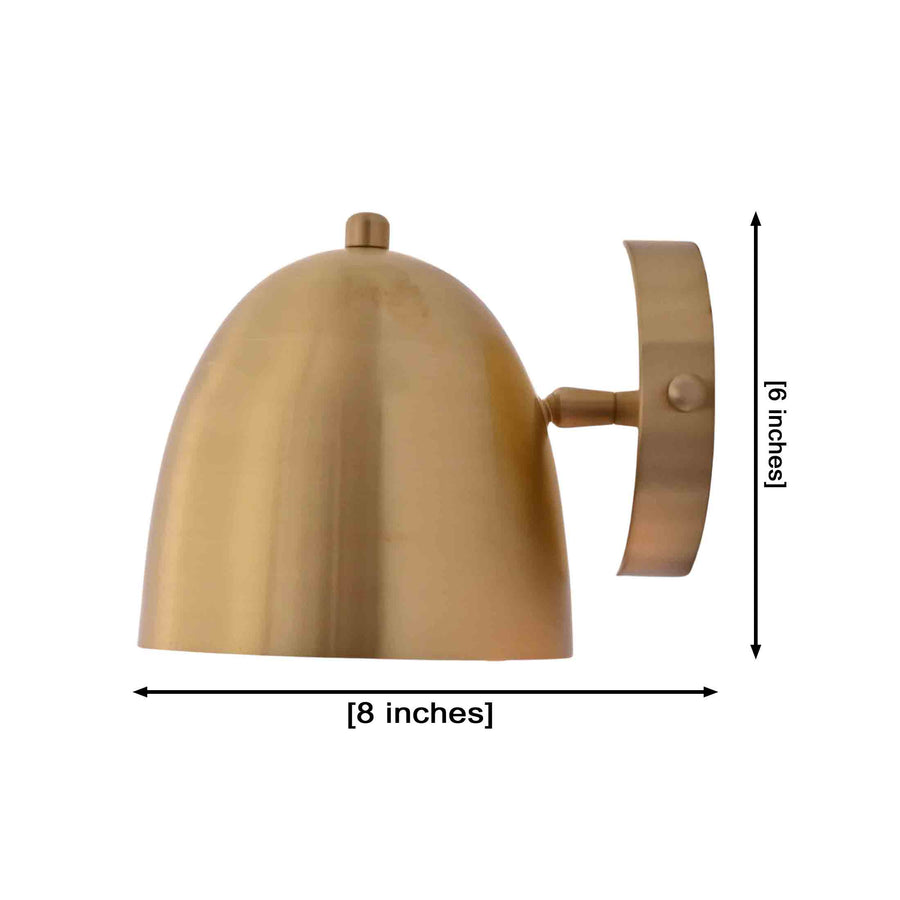 A modern dome-shaped wall sconce in a brushed brass finish, shown illuminated against a plain white background.