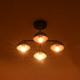 Warm glowing 4 light chandelier with dome brass shades illuminating in dim interior