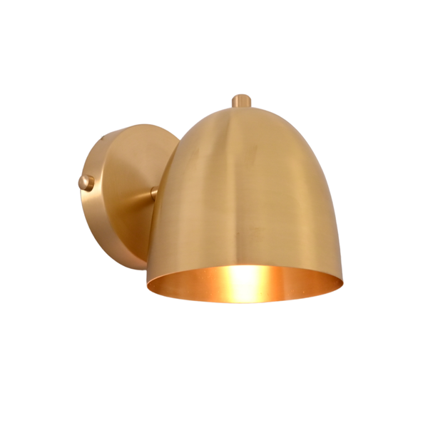 A modern dome-shaped wall sconce in a brushed brass finish, shown illuminated against a plain white background.