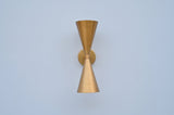 Front view of double cone wall light in brushed brass finish, handcrafted solid brass sconce with symmetrical up-and-down design.