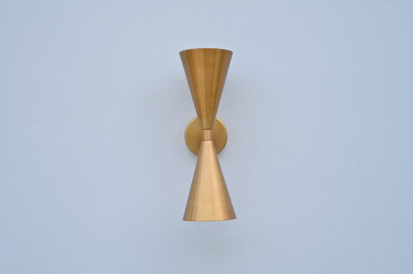 Front view of double cone wall light in brushed brass finish, handcrafted solid brass sconce with symmetrical up-and-down design.