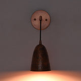 Front view of the Hudson Modern Hammered Copper Cone Wall Sconce mounted on a wall with warm downward illumination, showcasing the handcrafted hammered copper cone shade and minimalist design.