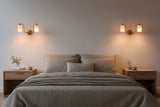 Dual alabaster cylinder wall light with curved brass arms and round brass patina canopy for elegant interiors