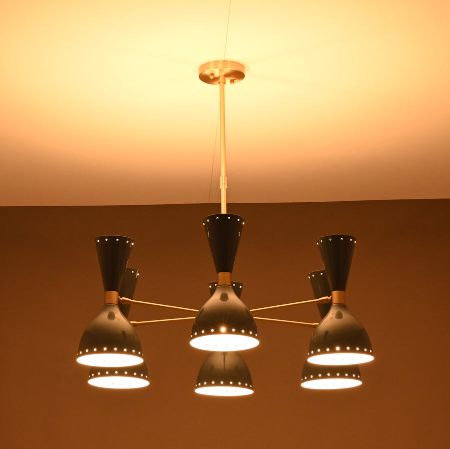 Mid-century modern dual-cone brass chandelier in a contemporary bedroom with soft lighting and blue accents.