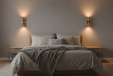 Dual cylinder brass patina wall light with solid brass body and soft upward and downward illumination