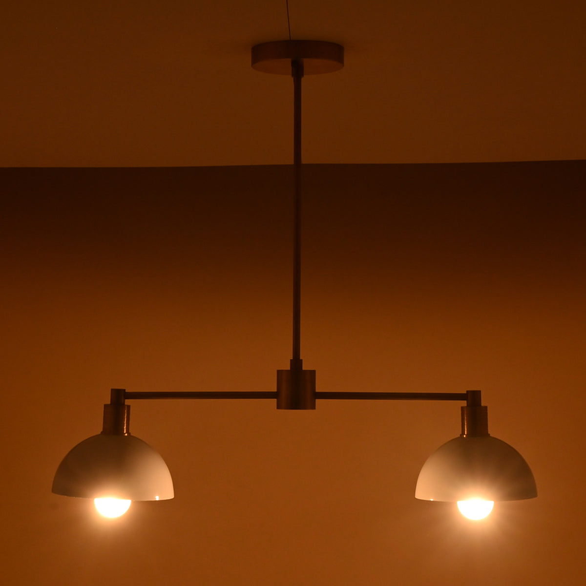 Two-light modern ceiling fixture in brushed brass and white dome shades, handcrafted for warm ambient lighting