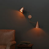 Solid brass dual shade wall light with adjustable arms and warm downward lighting for bedrooms and reading corners