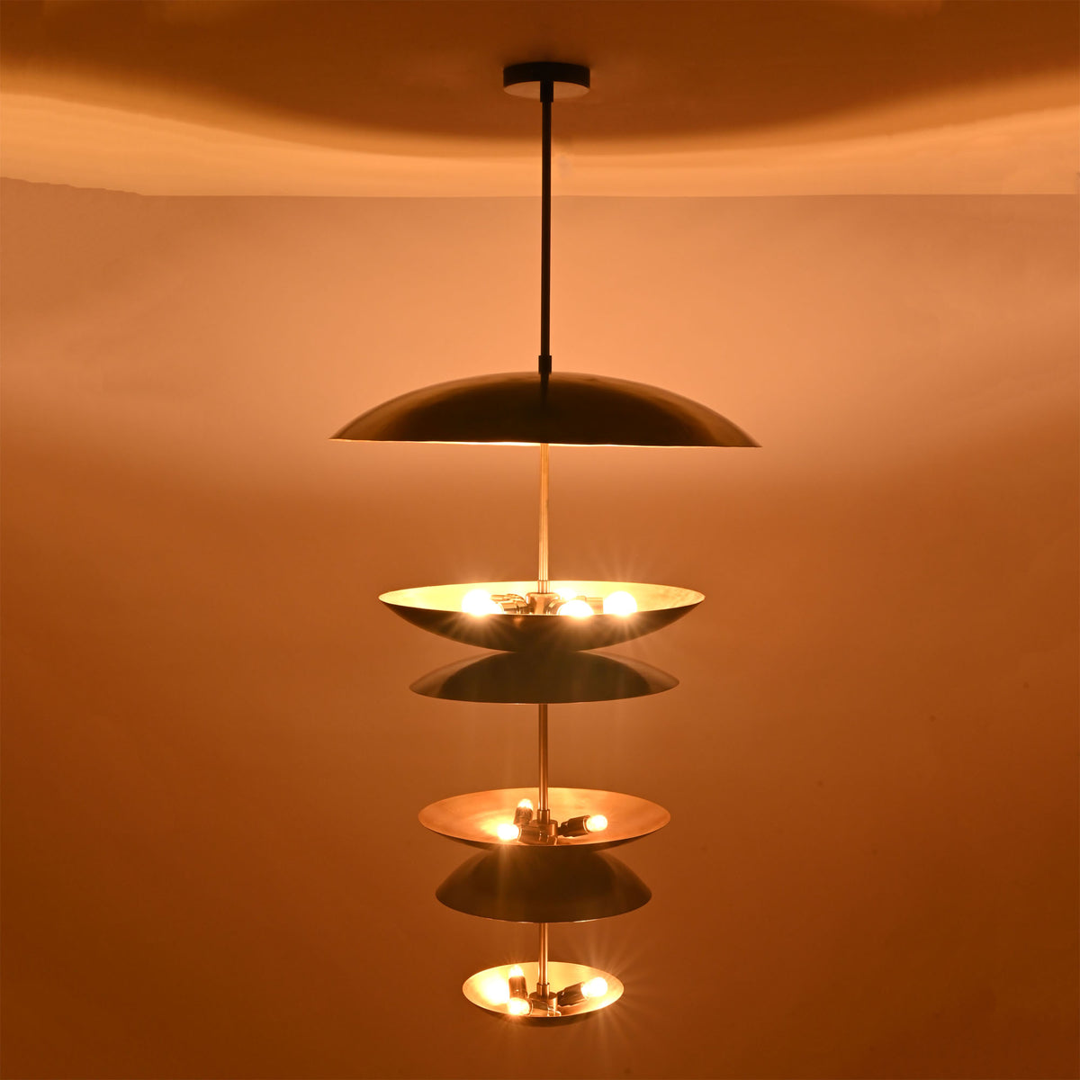Close-up illuminated view of Eclipse Cascade Chandelier showcasing sculptural multi-tier dish shades