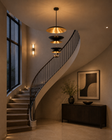 Eclipse Cascade Chandelier installed above a luxury curved staircase adding a dramatic architectural focal point