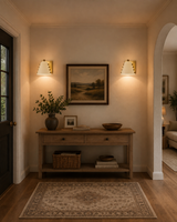 wo wall sconces used in entryway with warm downward glow above console table and decorative wall art