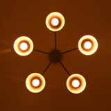 Symmetrical bottom view of five-light brass chandelier highlighting circular cone shades and warm central glow.