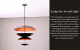 Designer chandelier with layered black and copper discs, creating architectural elegance