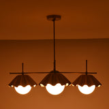 Bottom view of four-light brass chandelier showcasing warm indirect lighting and scalloped shade edges.