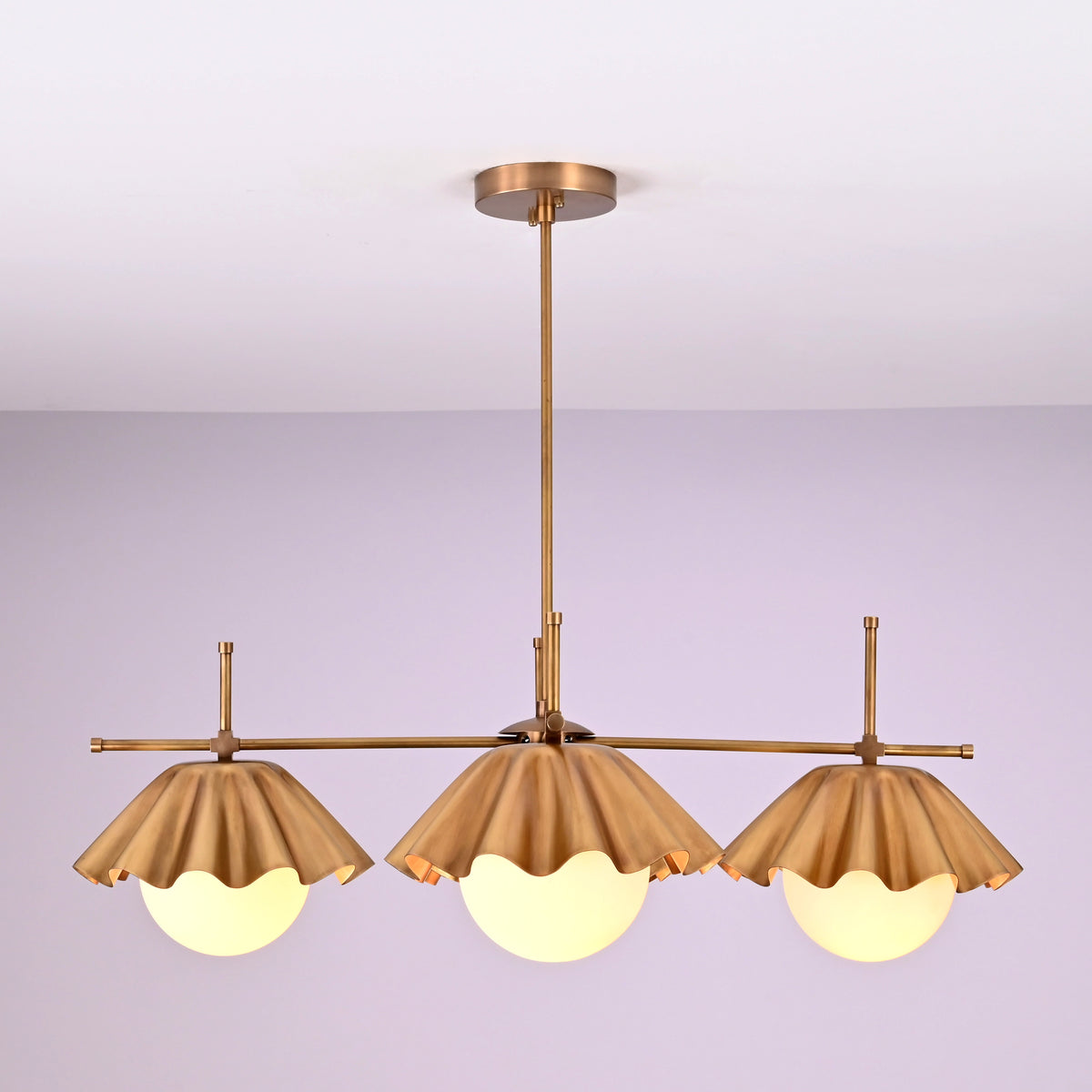 Linear profile view of four-light brass chandelier featuring fluted bowl shades and balanced symmetry.