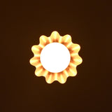 Bottom glowing view of brass pendant lamp with ruffled shade and globe bulb casting ambient light