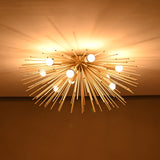 Golden Flare Chandelier with brass rods extending outward from central base, LED bulbs lit