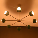 Green bowl sputnik chandelier casting warm indirect light across ceiling with soft modern ambiance