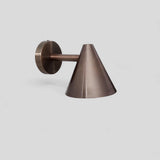 Handcrafted wall light in brushed antique brass finish with simple cone design, perfect for modern and industrial interiors.