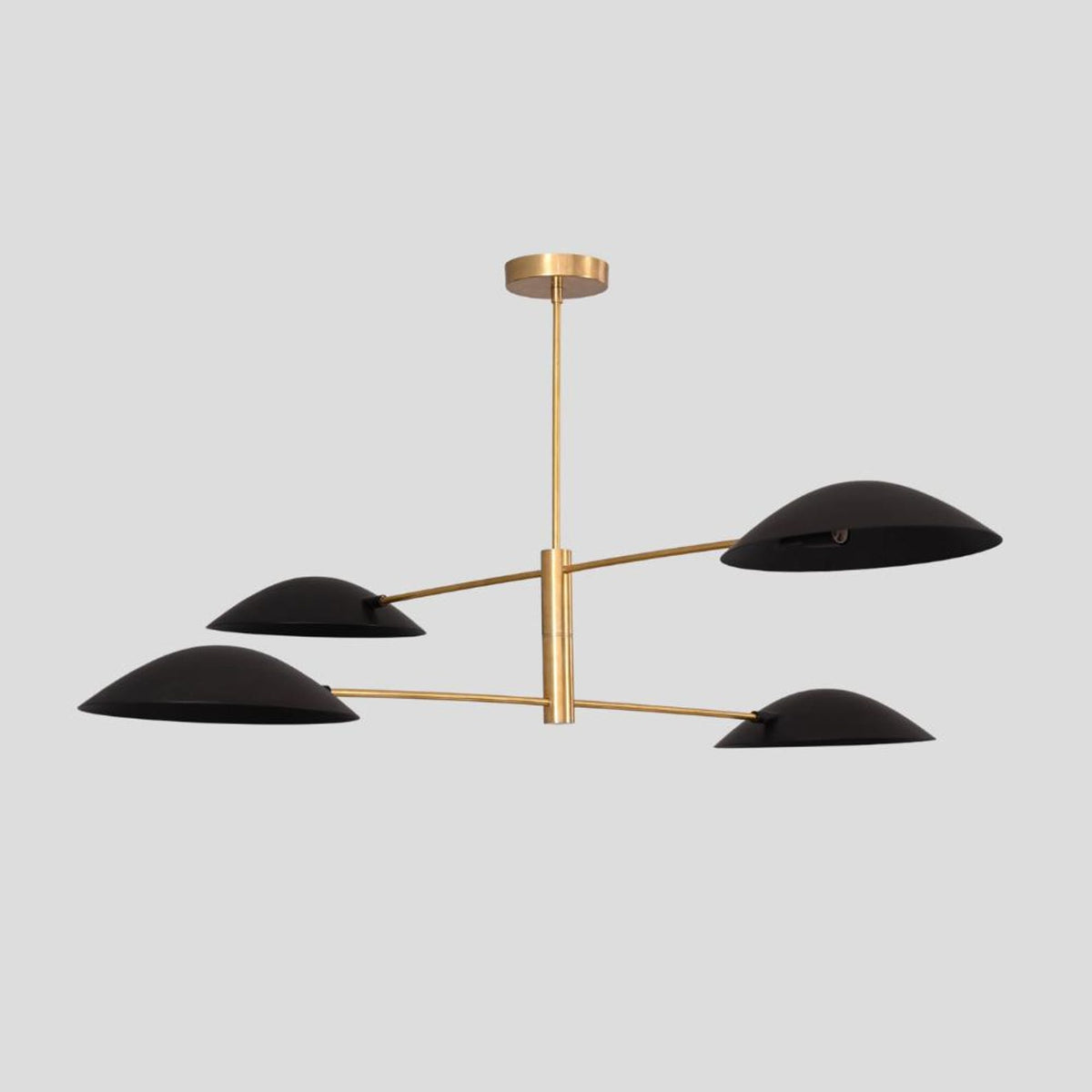 Handcrafted 4-light brass chandelier with black half-bowl shades, blending industrial and minimalist style for elegant interiors.