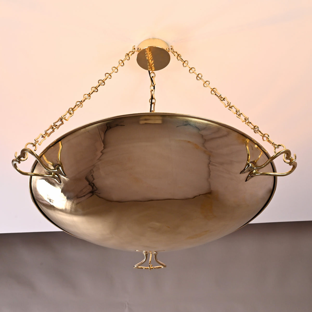 Handcrafted brass bowl chandelier with ornate sculpted handles and chain suspension