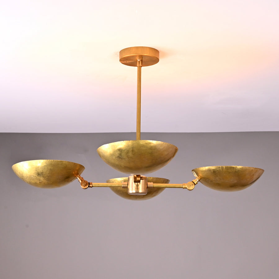 Front angle view of handcrafted solid brass chandelier with four hammered bowl shades and central brass rod suspension.