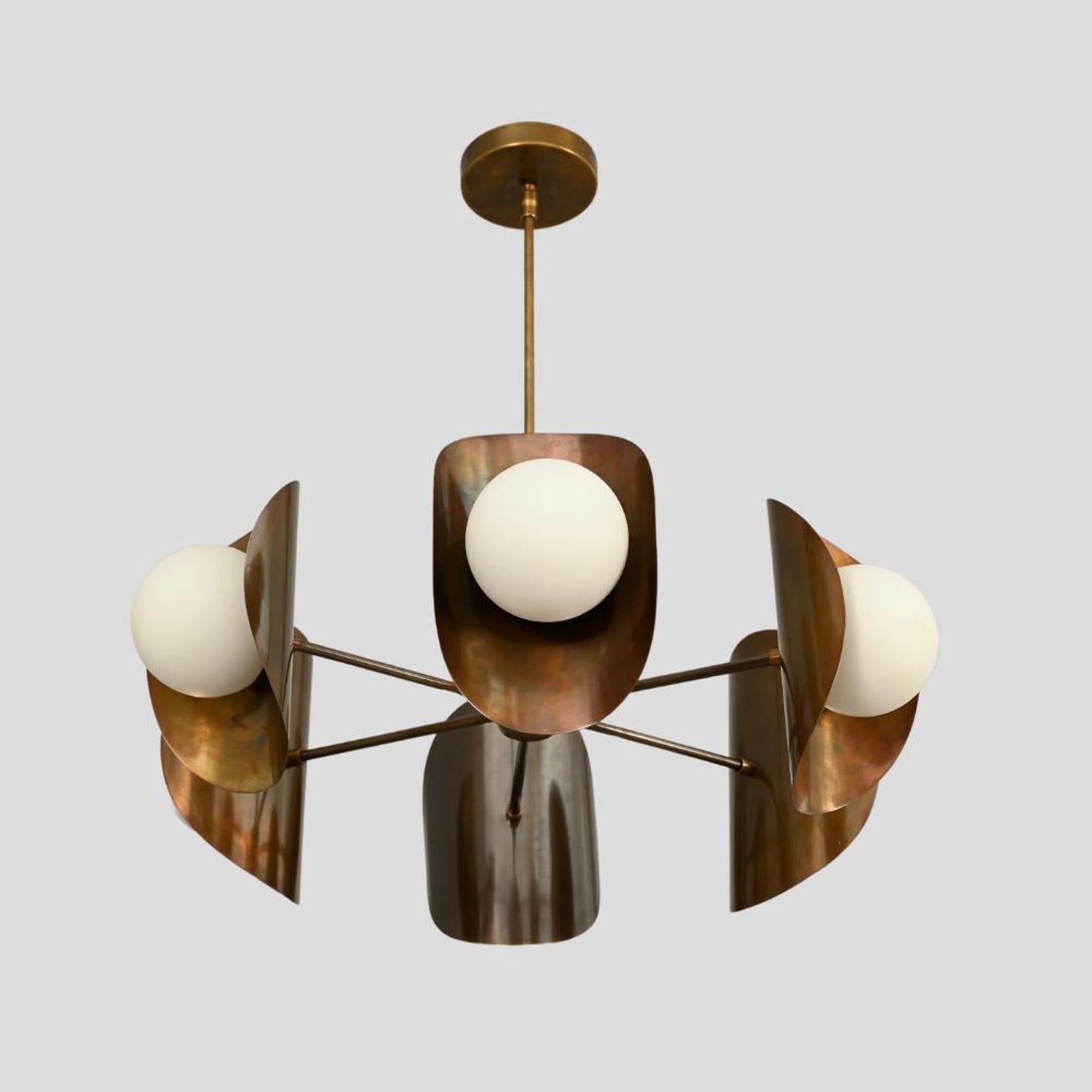 Handcrafted brass ceiling chandelier with brushed finish, three frosted glass globes, and sculptural bowl-shaped shades.