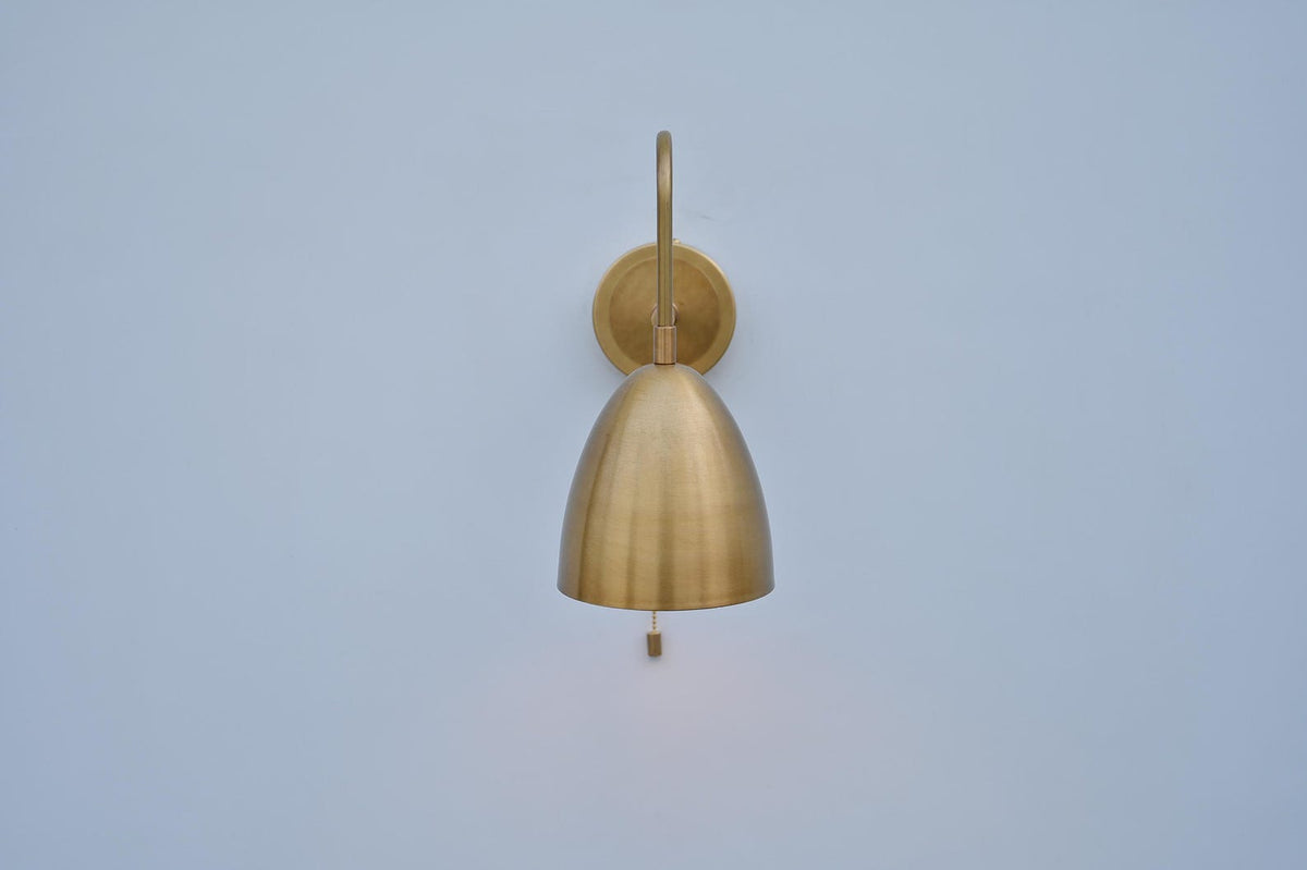 Front view of handcrafted brass dome sconce highlighting its curved dome shape and sleek wall mount in brushed brass finish.