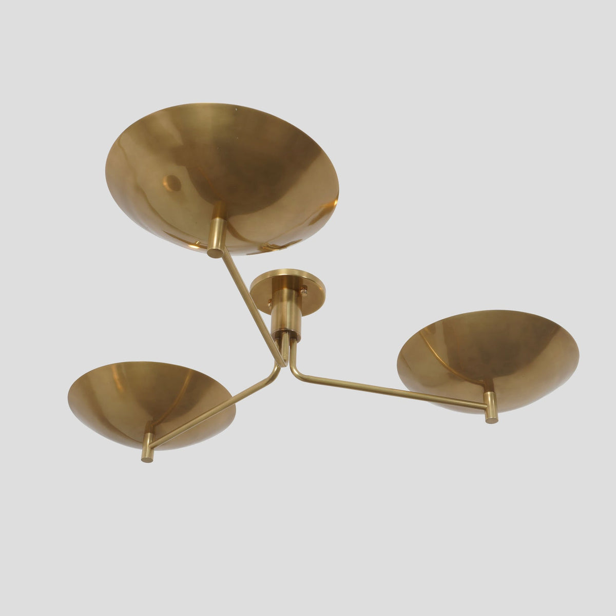 Side angle view of handcrafted 3-light brass flushmount fixture featuring smooth curved bowl shades