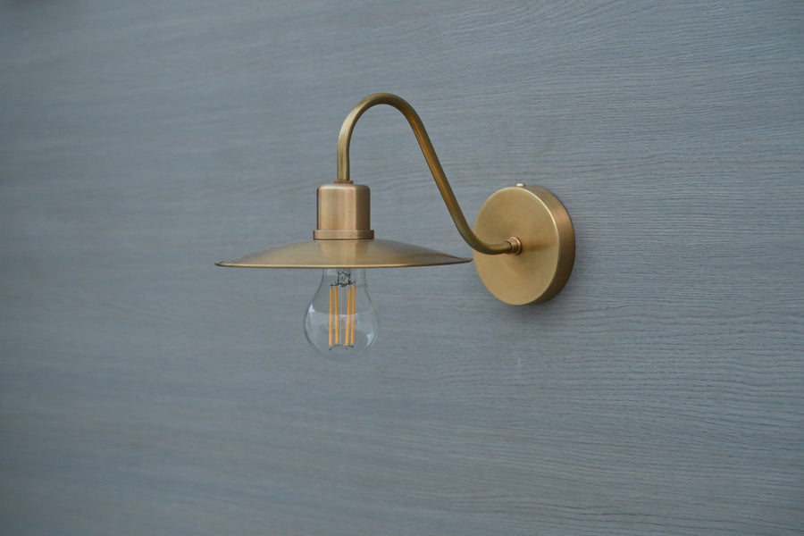 Side view of vintage brass gooseneck wall light with exposed bulb, handmade by Brass Leaf Studio in brushed satin brass finish