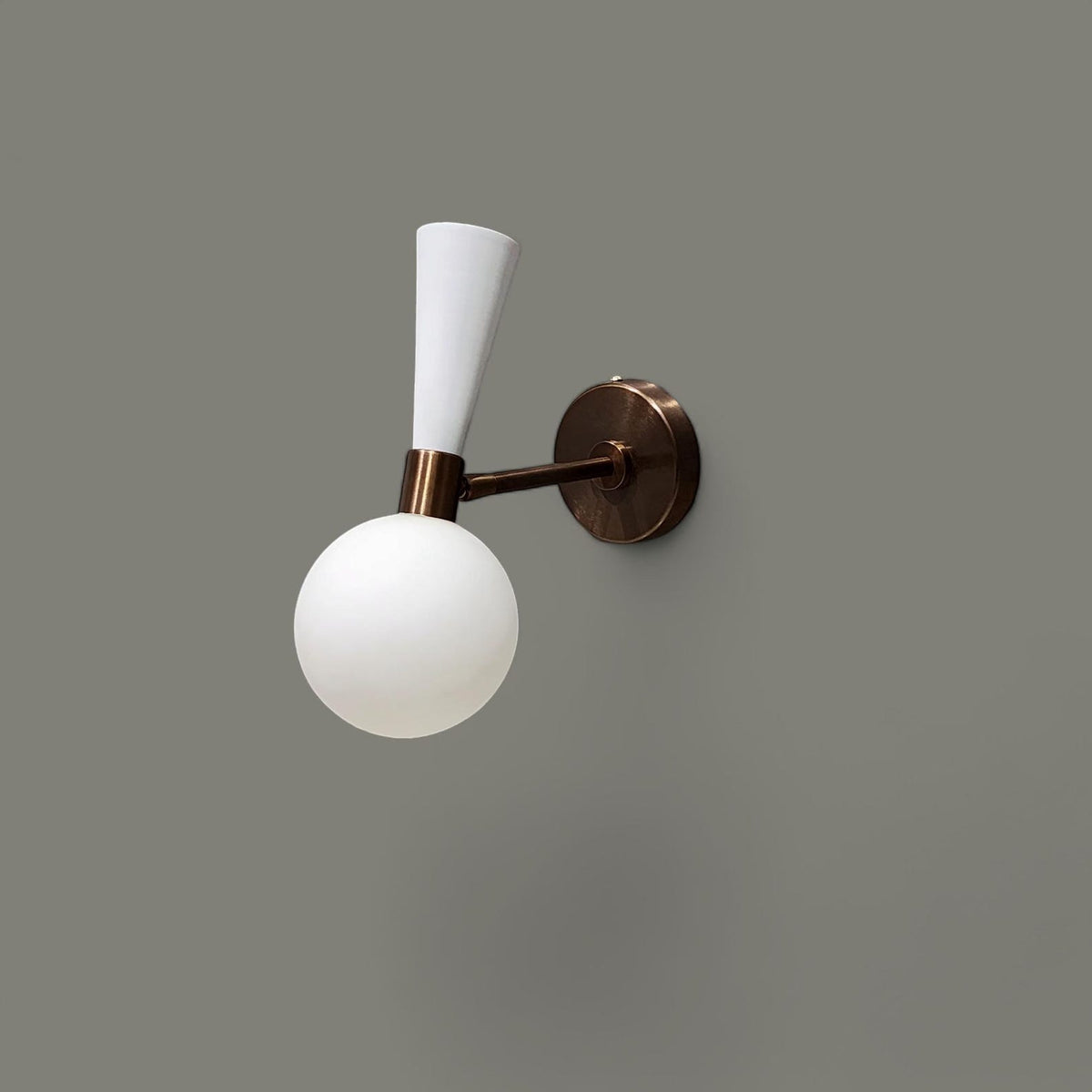 Handcrafted brass and white globe wall light with minimalist design and opal glass shade