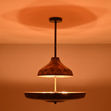 Handcrafted copper disc chandelier enhancing warm interior ambience with indirect brass lighting