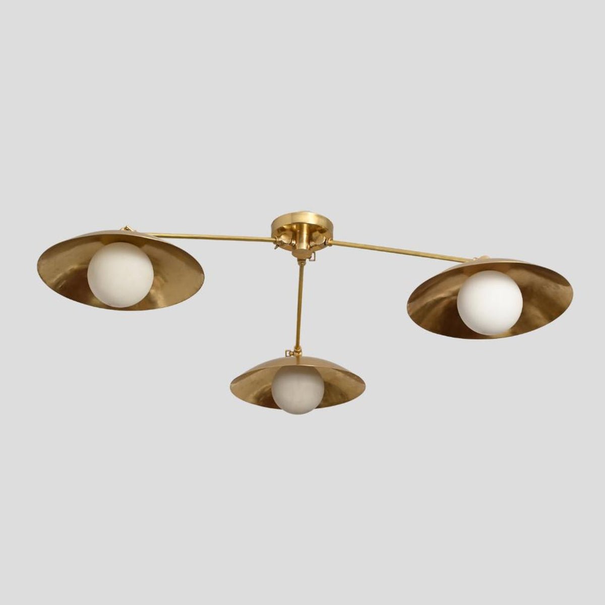 Overhead view of handmade brass 3-light chandelier with minimalist design and lacquer-coated bowl shades for elegant ambient lighting.