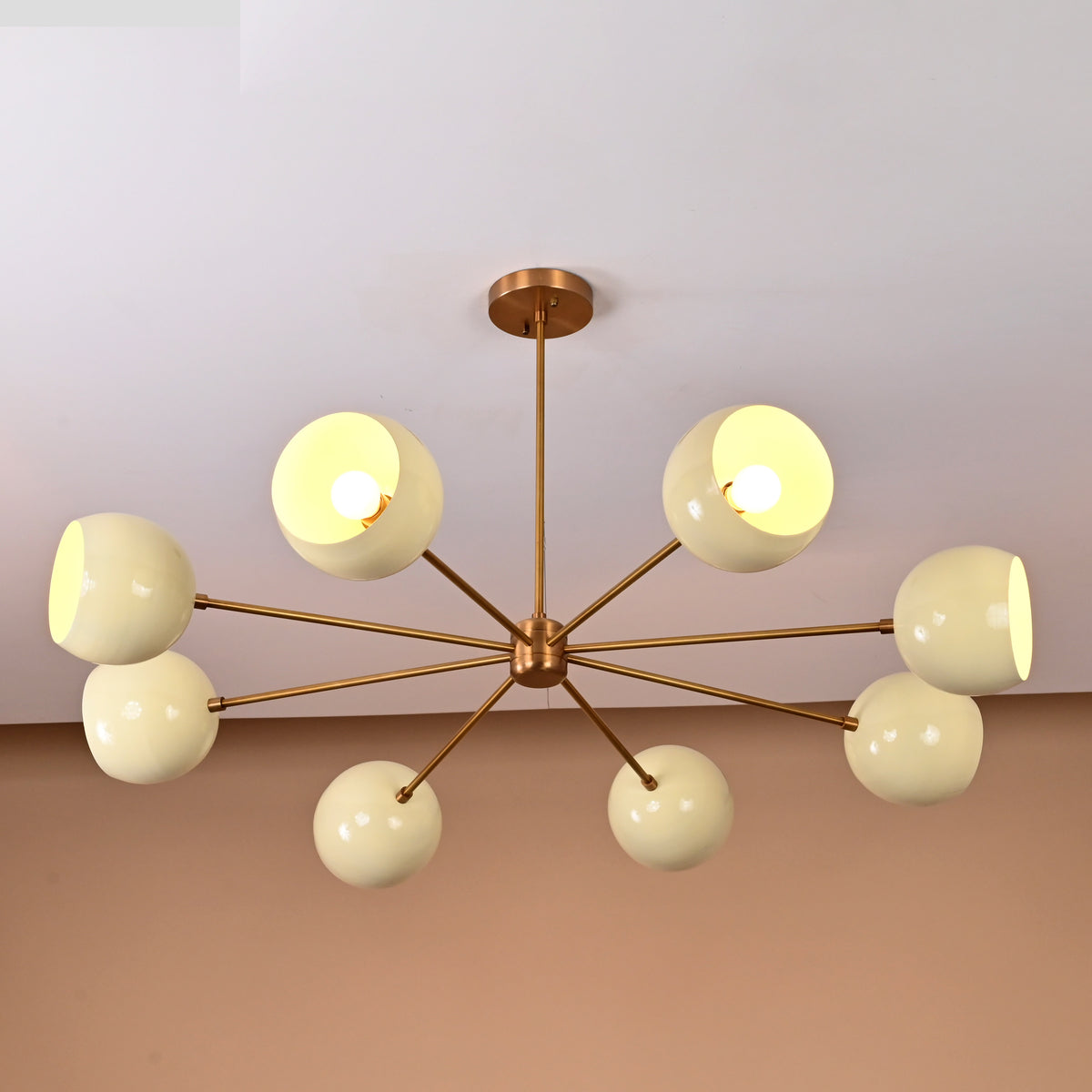 Handcrafted 8-light brass ceiling fixture featuring cream domes and minimalist modern symmetry