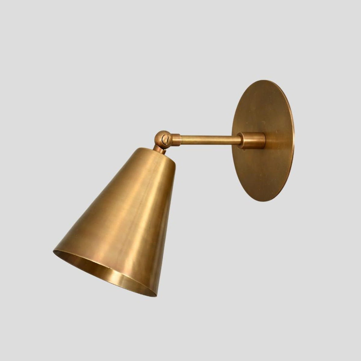Handmade brass wall sconce with cone-shaped shade, modern minimalist industrial wall-mounted light fixture.