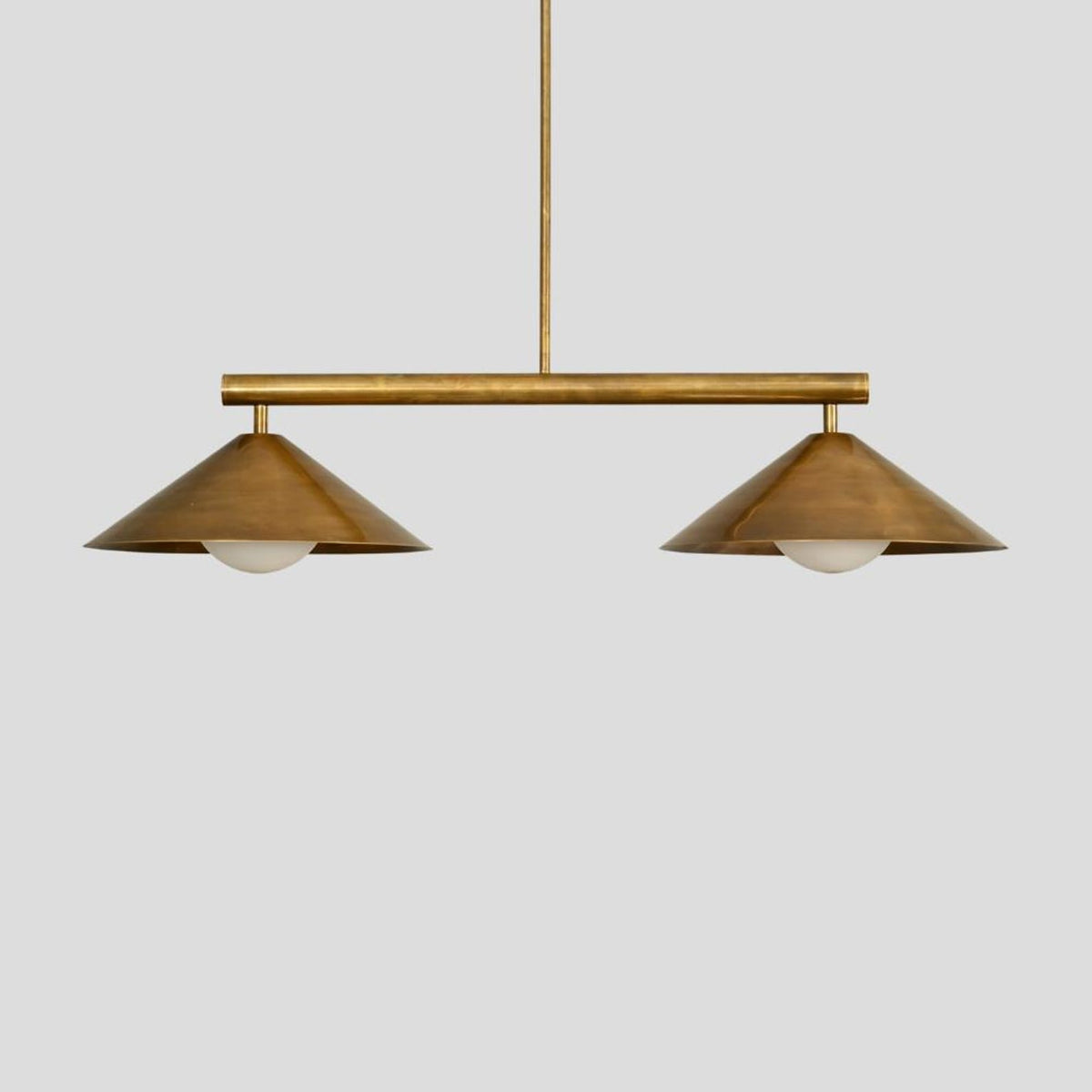 Handmade brass chandelier with two cone-shaped shades, a minimalist pendant light for living spaces and boutique interiors.